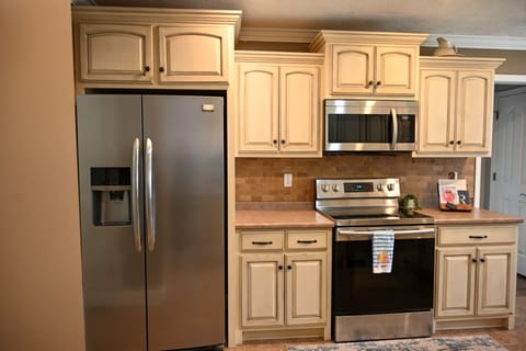 Fully stocked kitchen with new stainless steel appliances, electric stove