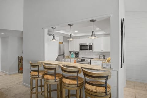 Your fully equipped kitchen features a breakfast bar where you can enjoy morning coffee while planning your day's adventures.