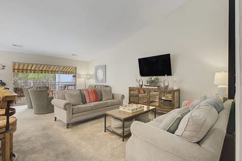 Sink into plush sofas in your spacious living room, where natural light streams through the patio doors and entertainment awaits on the large TV.