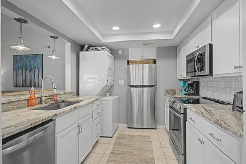 You'll love preparing meals in this stunning modern kitchen with granite countertops, stainless steel appliances, and elegant pendant lighting.