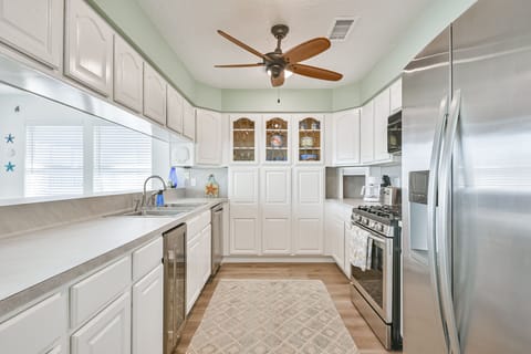 A nice open kitchen with stainless steel appliances and plenty of pantry space.