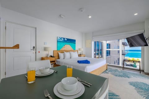 Your bright, modern retreat features a comfortable king bed, cozy dining nook, flatscreen TV, and private balcony with glimpses of tropical turquoise waters just beyond.