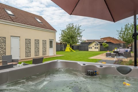 Grace Cottage, Heacham: Hot tub looking down the garden to outside dining areas beyond
