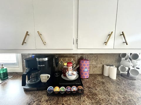 Coffee bar with Keurig and full pot. There’s a coffee bean grinder and K-cups.