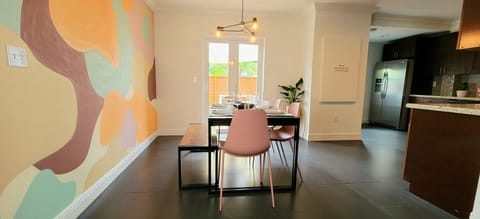 Dining room with beautiful tropical mural and view to private deck patio.