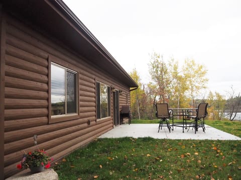 Patio with high top table, chair and gas grill.
