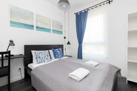 A cozy bedroom featuring a double bed, blue-themed decor, and bedside tables with lamps.