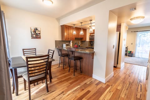 Open dining area near the kitchen, which opens up to patio with grill