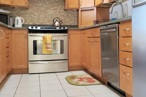 Spacious kitchen with stainless steel appliances - refrigerator, oven/stove, microwave, and dishwasher. Design home with modern amenities