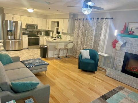 Open living/kitchen space with 55 in Smart TV and fireplace