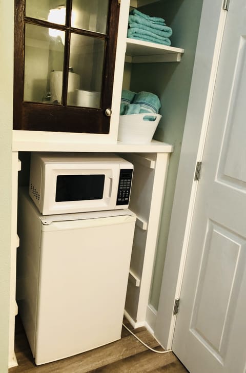 Studio’s kitchenette: fridge, microwave, coffee pot, dishes/tableware