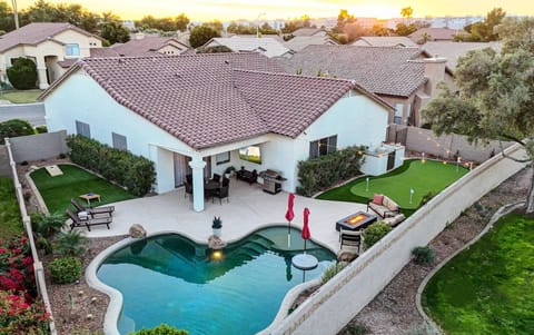 Resort-style backyard with private pool, 4-hole putting green, ping pong, cornhole, and a 75” smart TV on a covered patio, located in Chandler’s highly desirable Ocotillo community in Chandler, Arizona.