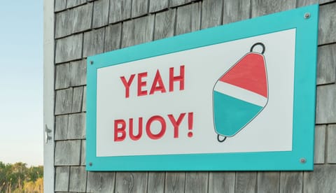 A cheerful nautical sign welcomes guests with coastal charm and playful maritime spirit at this waterfront property.