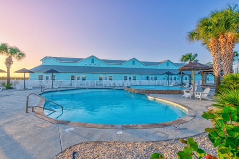 A stunning beachfront property featuring a sparkling pool surrounded by swaying palms, where golden sunsets paint the sky in magical hues.