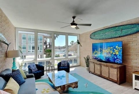 Unwind in your coastal living room with beach-themed decor, large windows overlooking the marina, and comfy seating perfect for movie nights.