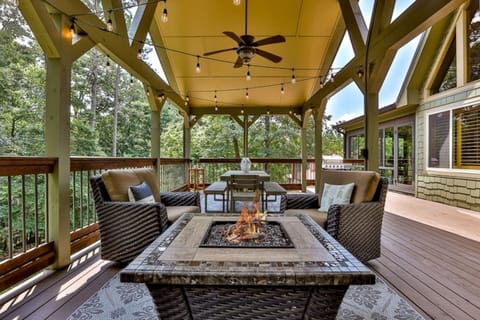 String lights, a lounge area with a fire pit and a large outdoor dining table complete the upper deck.