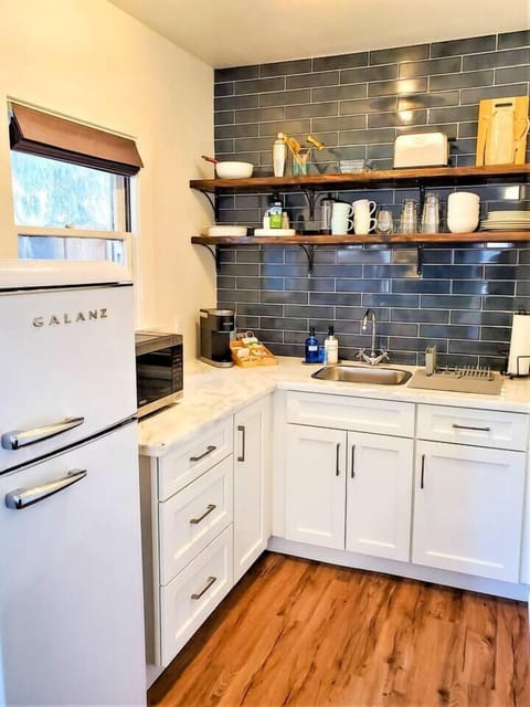 The kitchen is equipped with a medium fridge/freezer, double burner hot plate, 2-in-1 microwave and toaster oven, Keurig coffee maker, French press, and everything else you'd need to make or enjoy a meal.