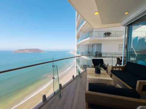 Oceanfront balcony with panoramic sea views and cozy seating