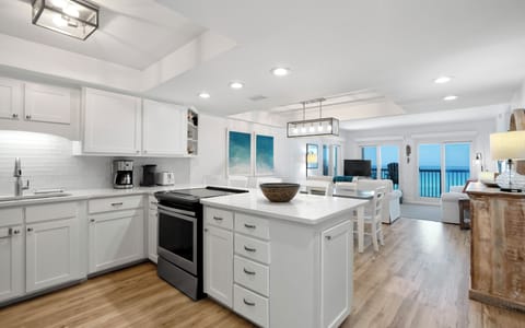 Your fully equipped kitchen flows seamlessly into the bright living area with stunning ocean views through expansive windows.