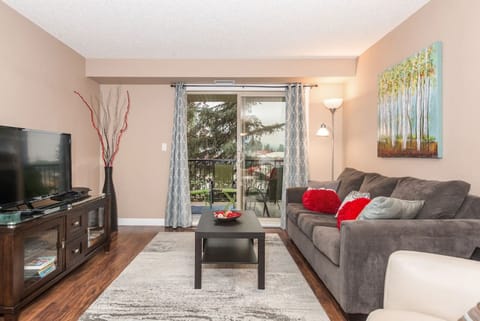 Living room with a TV, DVD player, Playstation 3 and a selection of games, and walkout access to the private balcony.