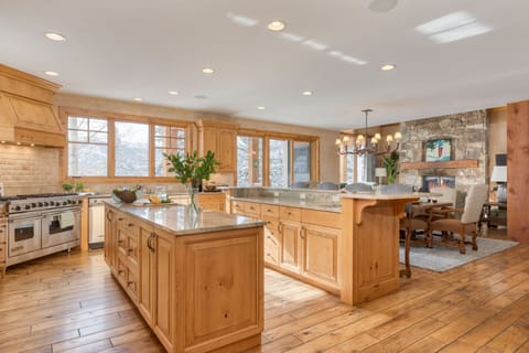 Large chef's kitchen features two islands, barstool seating, and top-of-the-line appliances.