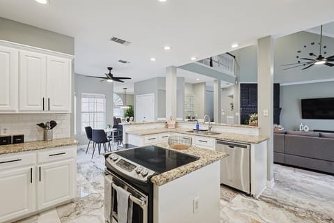 Bright Open-Concept Kitchen with Ample Storage & Stainless Steel Fridge