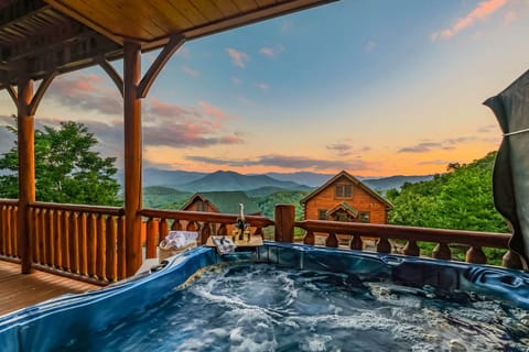Unwind in the hot tub while admiring the Smoky Mountain view (wine is for staging purposes, not included in stay)