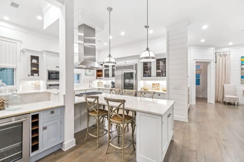 Gather around this gorgeous white kitchen island where marble countertops invite morning coffee and evening conversations under elegant pendant lighting.