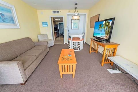 - Cozy and well-lit living space with a comfortable sofa and entertainment setup - Open layout connecting the living area to the dining and kitchen for convenience - Ideal for relaxing after a day at the beach or exploring local attractions