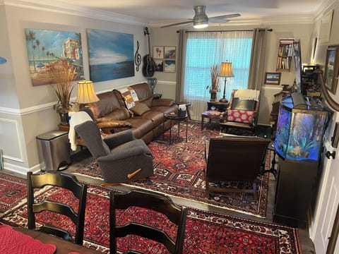 Living room features a 75 inch smart tv w/ 3 recliners & seating for 6