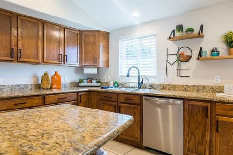 Large open fully stocked kitchen w/ stainless steel appliances and granite countertops w/ seating
