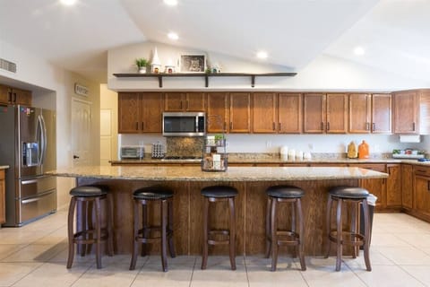 Large open fully stocked kitchen w/ stainless steel appliances and granite countertops w/ seating