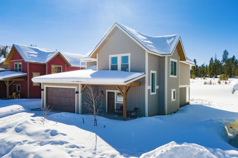 Cozy mountain retreat nestled in pristine winter wonderland, featuring modern architecture and covered porch perfect for snowy getaways.