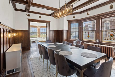 Formal dining room with Art Deco-inspired dining table for up to 10, open to solarium