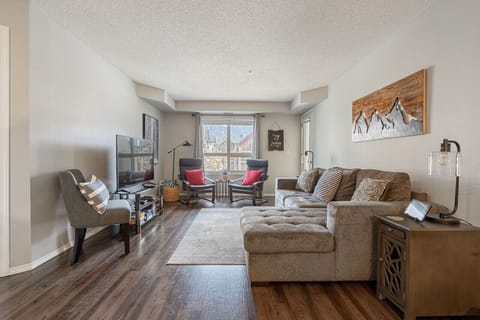 Living room with a smart TV, cozy seating options and a queen-sized pull-out sleeper sofa (all bedding provided.)