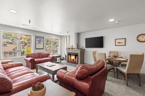 The living room with comfy red leather furniture and cozy fireplace.