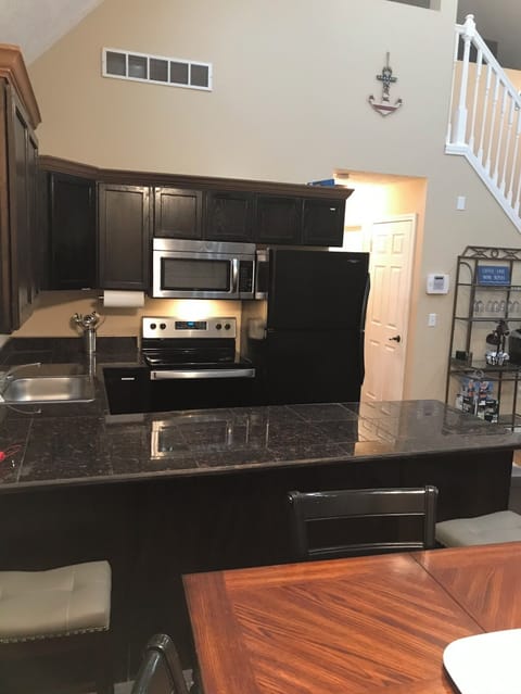 Kitchen with pots, pans, dishwasher, drip coffee maker, cups and a ice maker