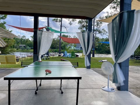 A large entertaining space with ping pong table, fire pit and view of the lake