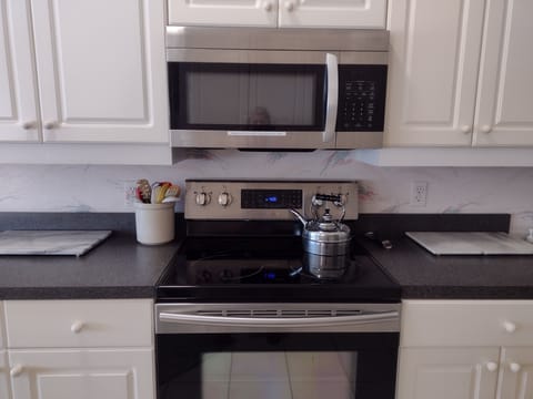 A clean kitchen complete with a tea kettle!