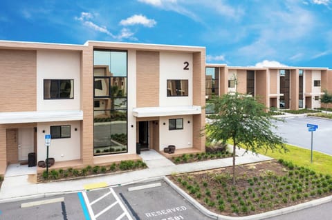 Modern townhome exterior with sleek lines and tall windows, plus reserved parking at your doorstep. Resort-style community and easy access to amenities-welcome to your stay!