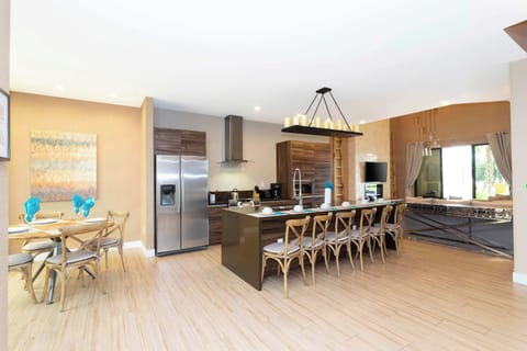 Spacious open-concept kitchen and lounge with stainless appliances, a long island with plenty of seating, and a foosball table-modern and perfect for gatherings.