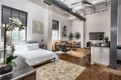 Unwind in this stylish, sunlit loft featuring a plush bed and an inviting open living space, perfectly blending comfort and modern design for a luxurious stay in the heart of Fort Worth’s vibrant downtown.