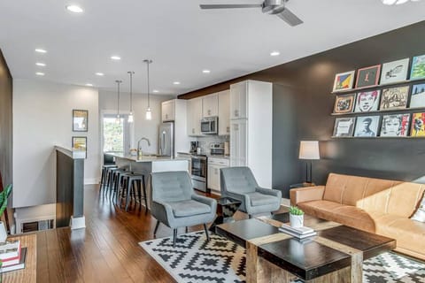 Open living room/kitchen area. Fully stocked kitchen with everything you could need. Smart TV in the living room. The two couches turn into futons. Private balcony right off the living room with a great view of downtown Nashville.