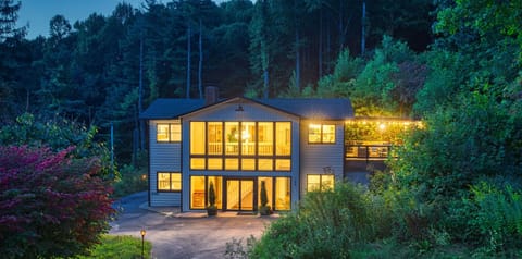 Wall of glass looks over mountain meadow Above Asheville Art House