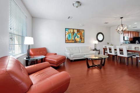 Relax in your open-plan living space with leather seating, modern art, and a full kitchen perfect for family meals.