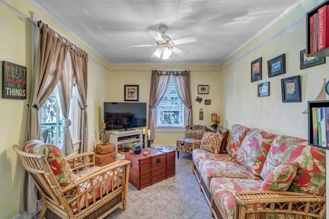 - Gather in this cozy living room with floral rattan furniture, TV, and relaxed vibes
- Decorated with uplifting quotes and art, this space is full of personality
- Natural light and ceiling fan make it a cheerful and inviting retreat