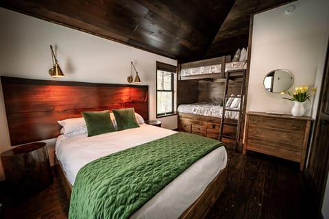 Main bedroom with queen bed and full bunks. Windows have room darkening shades.