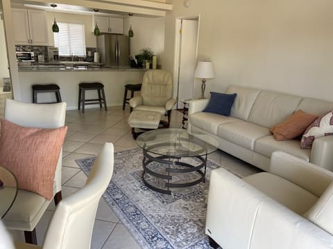 Open living room with dining area. Extremely large television and comfy couches

