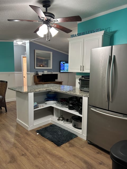 Kitchen large open cabinet with cookware under granite island. 