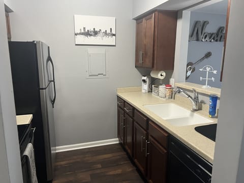 View of kitchen showing sink, dishwasher, and single-cup coffee maker.